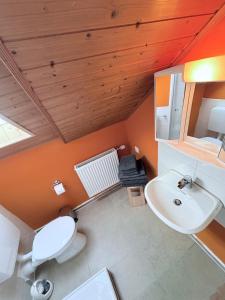 a bathroom with a white toilet and a sink at RelaxStay - Weserbergland in Heinsen +24 photos