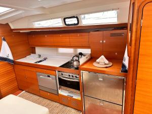 a kitchen with wooden cabinets and a stove top oven at Adria Yacht Porto Montenegro in Tivat