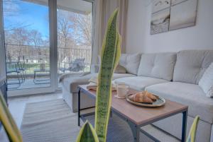 a living room with a surfboard and a table with a surfboard at HelApart - Casa Baia in Hel