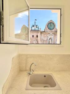 a window with a sink in front of a clock tower at Casa Garibaldi in Trapani