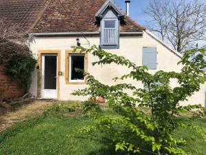 Bramble cottage في Saint-Didier-en-Donjon: بيت ابيض وفيه شباك وباب