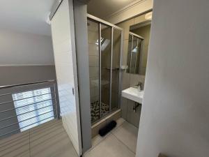 un baño con ducha y lavabo en Stylish Loft apartment in the heart of Durbanville, en Durbanville 13 fotos más
