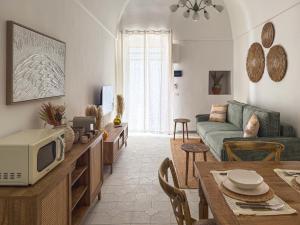 a living room with a couch and a table with a microwave at Dimora Pinto in Locorotondo
