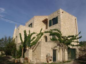 a stone building with a tree in front of it at Villa Aloni in Orthés