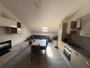 a kitchen and living room with a table and a couch at Rétrohome in Sulmona