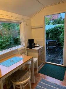 a kitchen and dining room with a table and a window at Strandnära Stuga Saga in Visby +10 photos