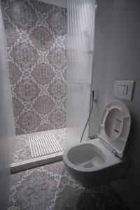 a bathroom with a toilet and a shower at Atola Outhouse Resort in Jāmb