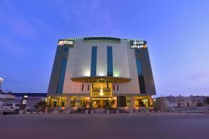 a building with a sign on the side of it at Rose Oasis Hotel in Najran
