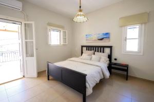 a bedroom with a large bed and a chandelier at Maria's Private Residence in Kalymnos