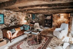 a living room with a couch and a table at La Petite Grange des Vignes in Jumilhac-le-Grand