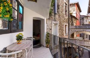 a balcony with a wooden table and a building at C’era una Volta in Isolabona