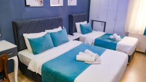 two beds in a hotel room with blue walls at Grand Bona Sera Hotel in Istanbul +217 photos