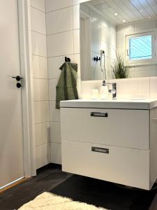 a white bathroom with a sink and a mirror at Tullikatu Two-Bedroom Apartment in Kristinestad +29 photos