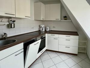 a kitchen with white cabinets and a sink at Ferienwohnung für 5 Personen in Dresden +6 photos