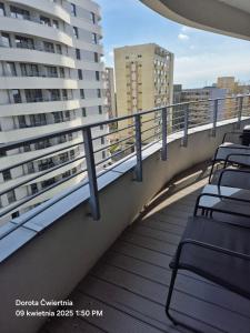 un balcon avec des chaises et des tables sur un immeuble dans l'établissement Apartament Sun Tower z Parkingiem, à Świnoujście