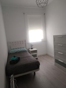 a bedroom with a bed and a window and a dresser at Entresuelo luminoso cerca de Escaño in Ferrol