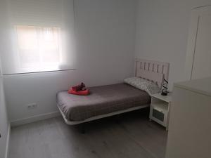 a small bedroom with a bed and a window at Entresuelo luminoso cerca de Escaño in Ferrol