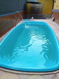 a large blue pool with a water hose in it at Spacious COP 30 home - Casa espaçosa COP 30 in Belém