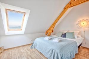 un dormitorio con una cama y una ventana en Gîte La Ligne Bleue front de mer et vue sur une Tour Vauban, en Saint-Vaast-la-Hougue