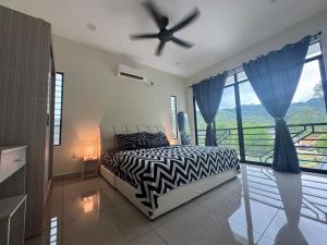 a bedroom with a bed and a ceiling fan at Vinzsugudhomestay in Penampang