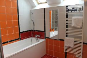 La salle de bains est pourvue de carrelage noir et orange. dans l'établissement Au Coeur De Beauvais, à Beauvais 35 autres photos