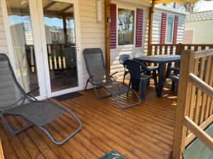 a porch with chairs and a table on a house at Mobilhome élégance in Valras-Plage