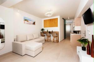 a living room with a couch and a table at Fortaleza Rooms Pefkochori in Pefkochori