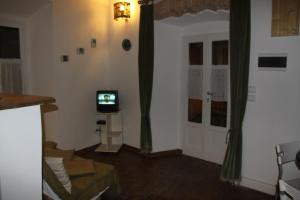 una sala de estar con TV en una habitación con cortinas en Belvedere, en Marciana Marina