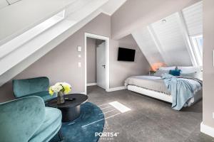 a bedroom with a bed and a chair and a table at Ferienwohung Genießen St Peter-Ording in Böhl