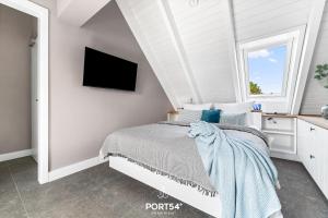 a bedroom with a bed and a tv on a wall at Ferienwohung Genießen St Peter-Ording in Böhl