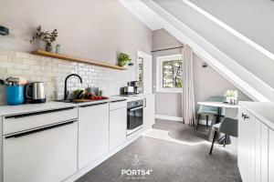 a white kitchen with white cabinets and a staircase at Ferienwohung Genießen St Peter-Ording in Böhl +13 photos