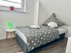 a small bedroom with a bed with black and white sheets at 3501 Weitblick über die Felder in Grönwohldshorst