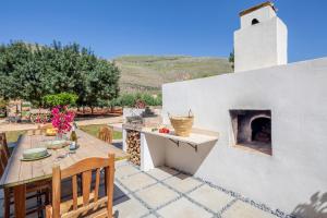a patio with a table and a fireplace at Case Vacanza Loria in Castelluzzo
