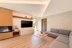 a living room with a couch and a flat screen tv at Serenity villa - Lake Como in Colico