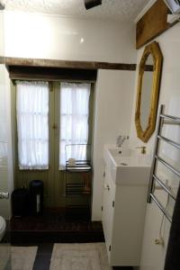 ein Badezimmer mit Waschbecken und Fenster in der Unterkunft Charming Historical Cottage in Bridgewater in Bridgewater