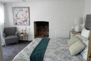 ein Schlafzimmer mit einem Bett und einem Kamin in der Unterkunft Charming Historical Cottage in Bridgewater in Bridgewater
