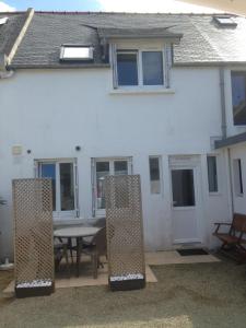 a white house with a picnic table in front of it at Les Coquillages in Trégastel