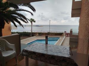 a balcony with a table and a view of the ocean at Apartamento Primera Línea de Mar en EbreHogar in L'Ampolla