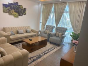 a living room with a couch and chairs and a table at jambo apartment 4 in Addis Ababa