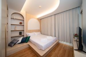 Un pequeño dormitorio con una cama y un televisor. en 全新现代风格 魅力泳池公寓, en Kamala Beach 24 fotos más