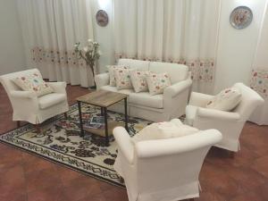 a living room with white chairs and a table at Hotel La Palma in San Teodoro
