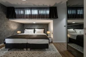 赫瓦尔Hotel - Teranea City Hvar的一间卧室配有一张大床和两张双层床。