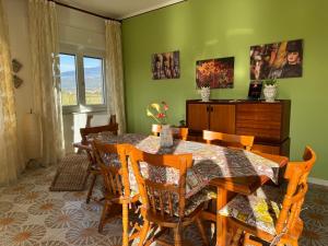 a dining room with a table and chairs at Green paradise with Etna view in Mascali