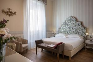 a bedroom with a bed and a table and a chair at Palace Hotel in Viareggio