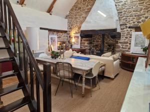 a dining room with a table and a stone wall at Gites Amorique Plesidy in Plésidy +2 photos