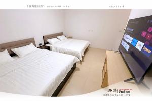 una camera d'albergo con due letti e una tv di 西衛參零陸民宿 Xiwei 306 Inn a Magong