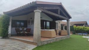 pergola ze stołem i krzesłami na patio w obiekcie Villa Janas con piscina privata Budoni w mieście Tanaunella +37 zdjęć