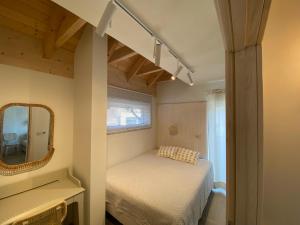 a small bedroom with a bed and a mirror at Choriatiki in Dębki