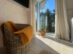 a wicker chair in a room with a large window at Choriatiki in Dębki