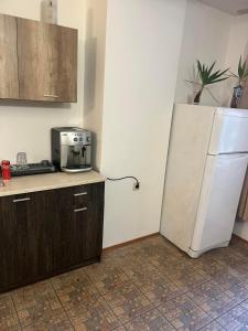 a kitchen with a white refrigerator in the corner at Хотел Стоянови in Ravda
